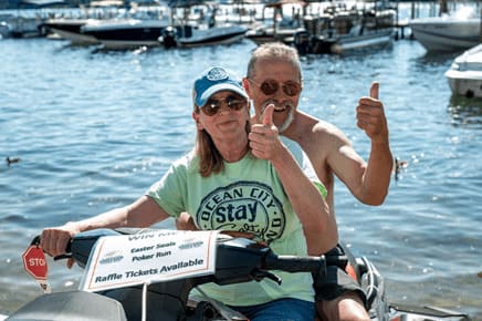 Two HK Powersports Land & Lake Poker Run participants smile as they gear up for Poker Run activities on Lake Winnipesaukee.