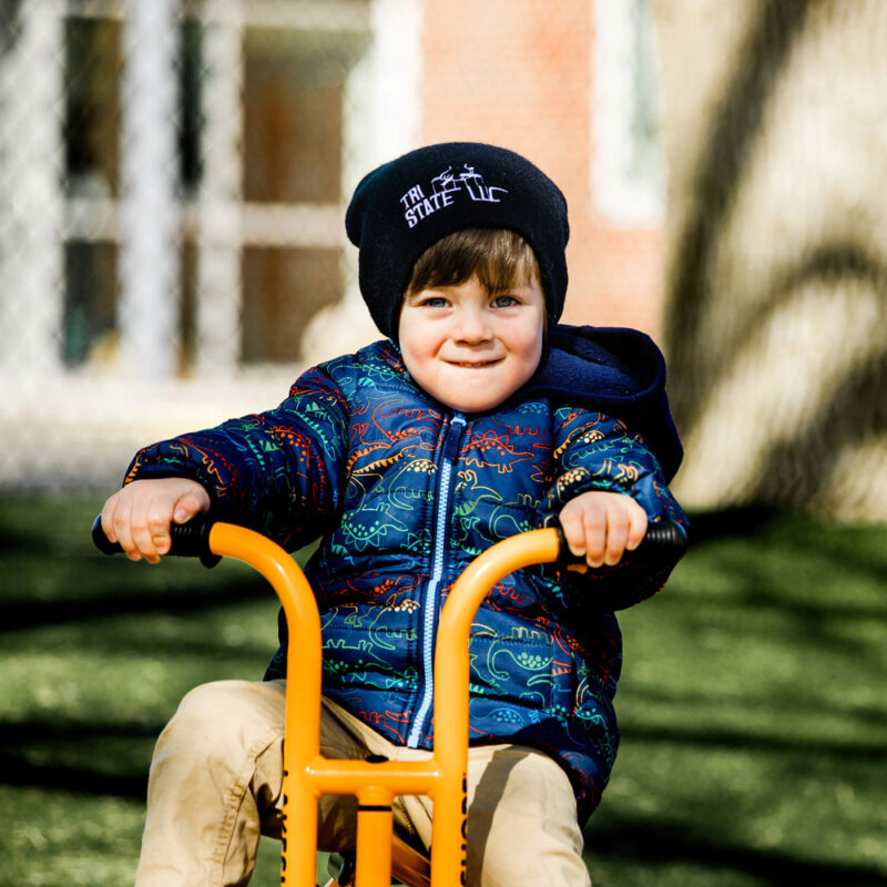 Young boy riding a bike outdoors.