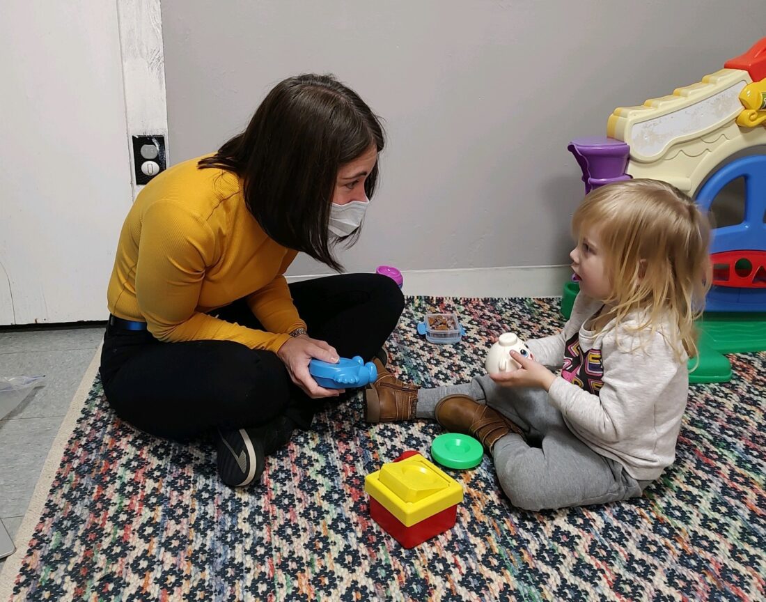 Elise works with a young child in the clinic.