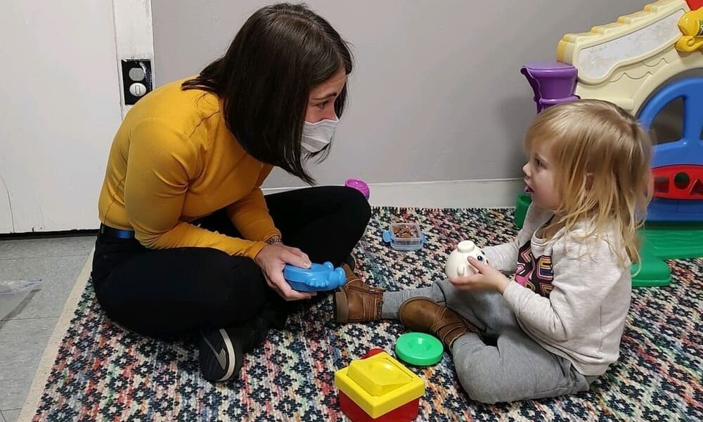 Elise works with a young child in the clinic.