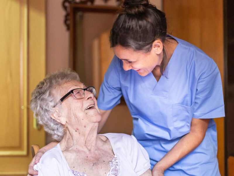 Happy Senior woman laughing. with her caregiver at home.