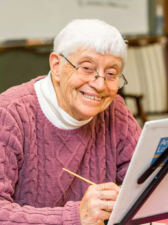 Older woman painting in adult day services.
