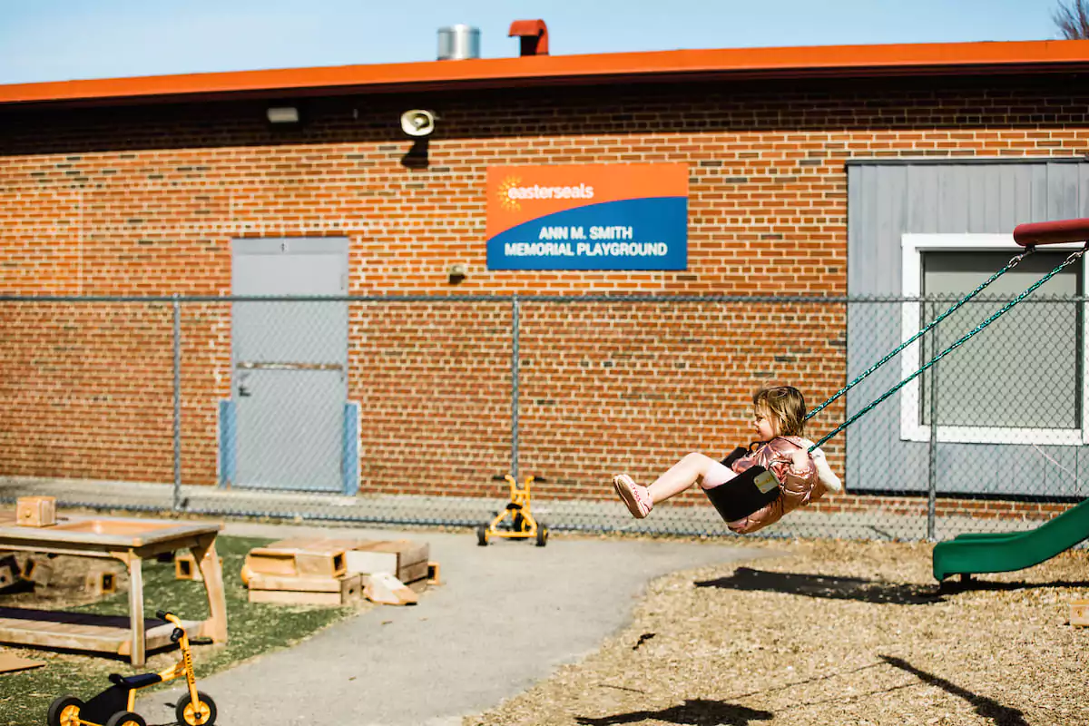 Young girl on a swing at the Easterseals NH playground.