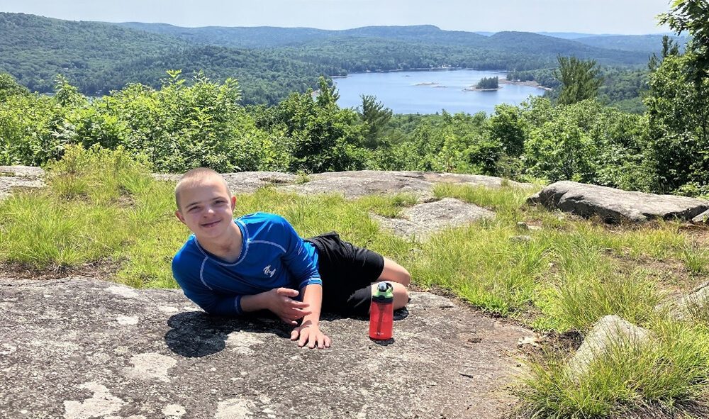 Lucas laying down on the top of a mountain