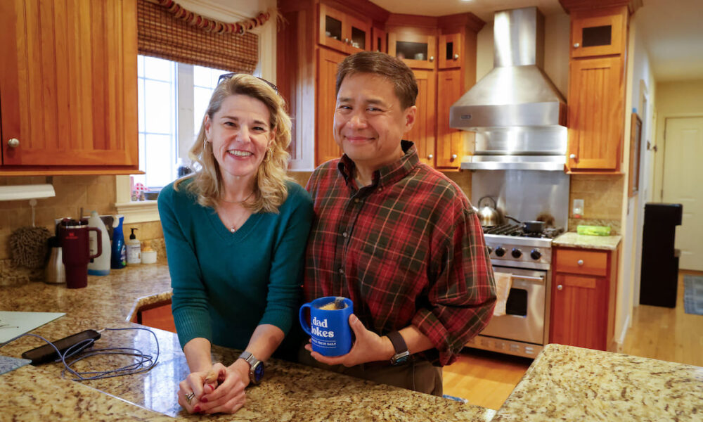 Man and woman smiling for photo inside of kitchen