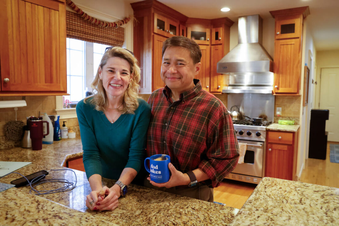 Man and woman smiling for photo inside of kitchen
