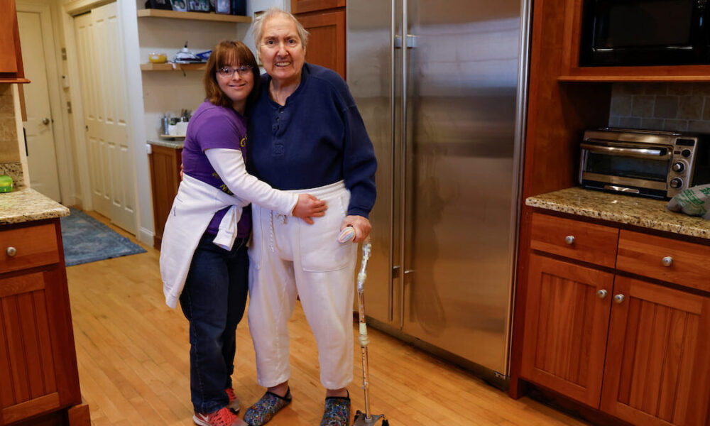 Marquis and Sue pose for a photo together inside of a kitchen.