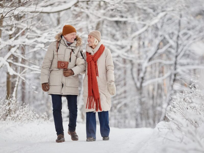 Man and woman walking through the snowy woods