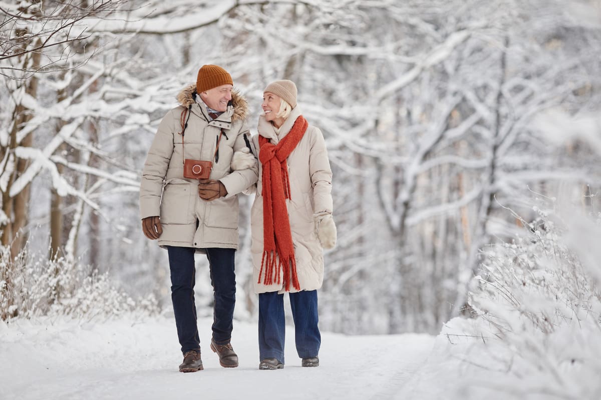 Man and woman walking through the snowy woods