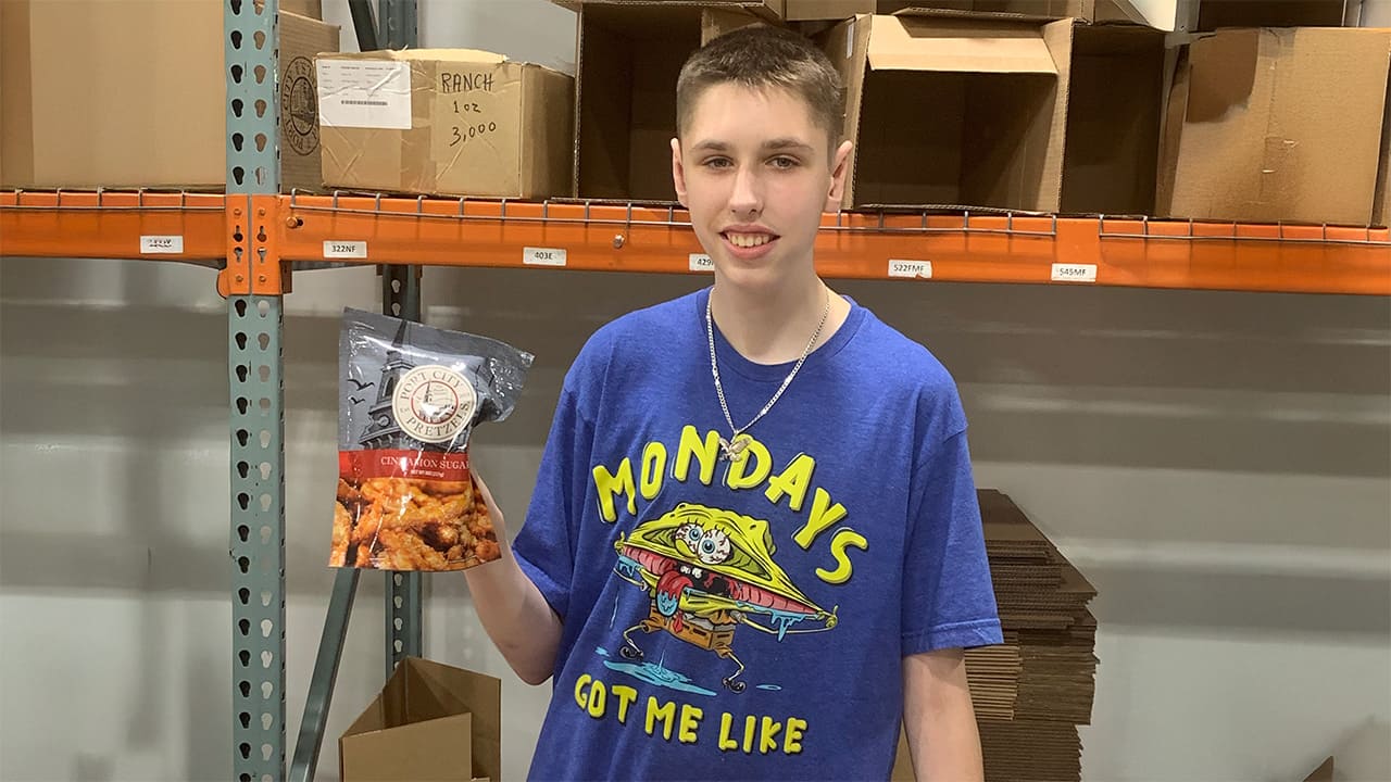 Aydan holding up a bag of port city pretzels