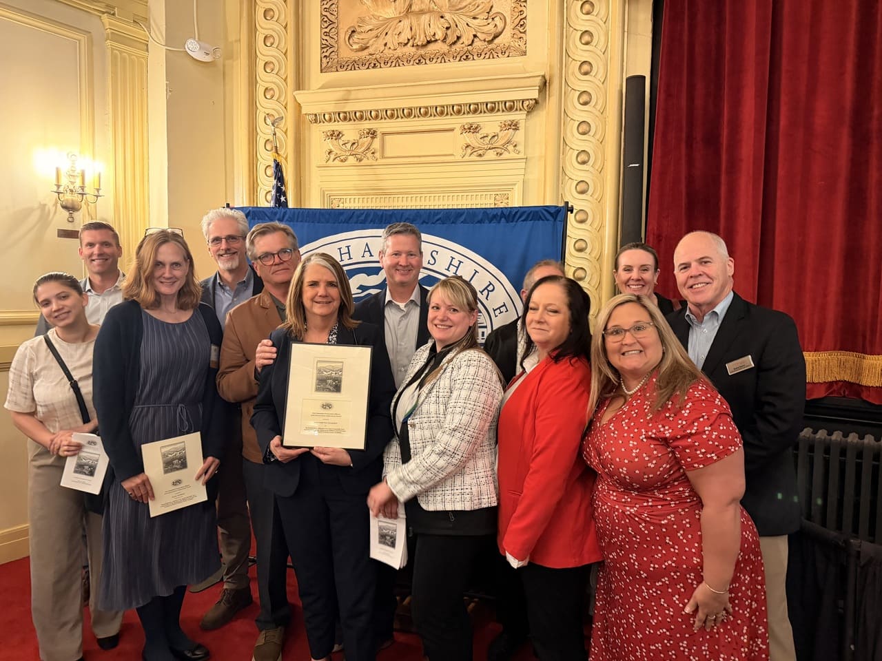 Proud Recipients of a 2026 Preservation Achievement Award Standing with the Award - Representatives from Easterseals NH & VT and PROCON celebrate the recognition of Easterseals NH winning a 2026 Preservation Achievement Award for the Easterseals NH Military & Veterans Campus, joining together to recognize the collaboration and commitment of preserving and strengthening historic community spaces in New Hampshire.
