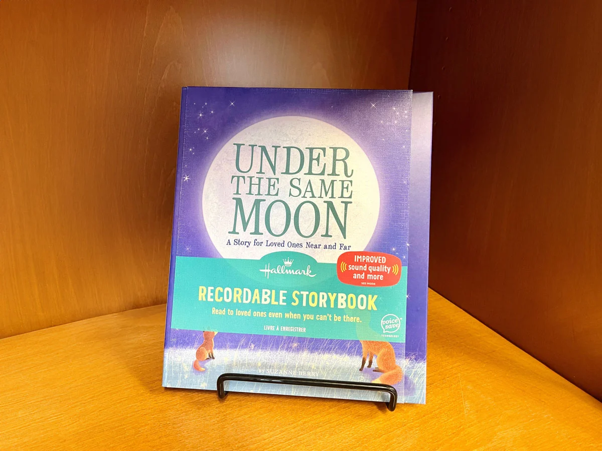 Book on a wooden shelf titled, "Under the Same Moon".